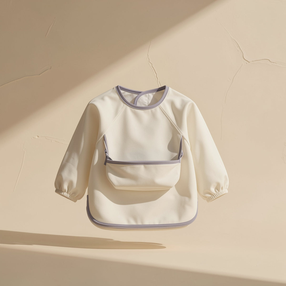 Long-sleeve toddler feeding bib with an enlarged pocket